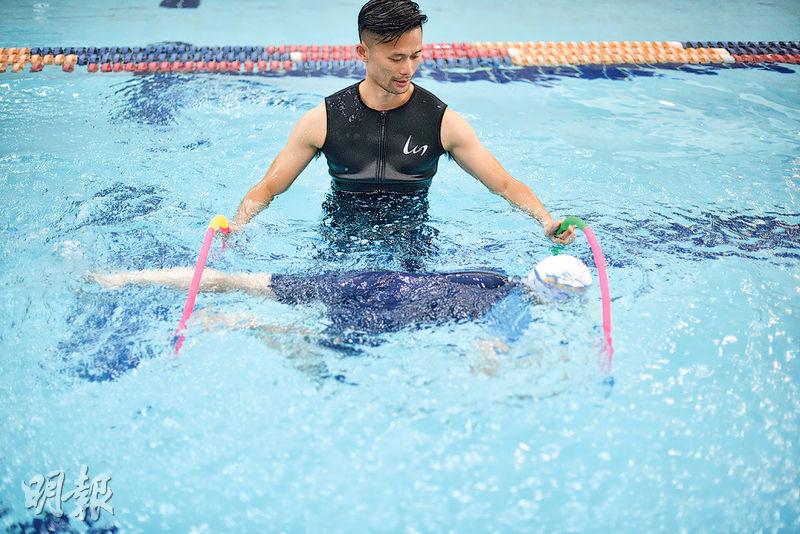 教SEN孩子學游水，使用的輔助工具特別多，其中一個做法是叫孩子穿過兩個呼拉圈，練習在水中前進之餘，他們又覺得好玩。